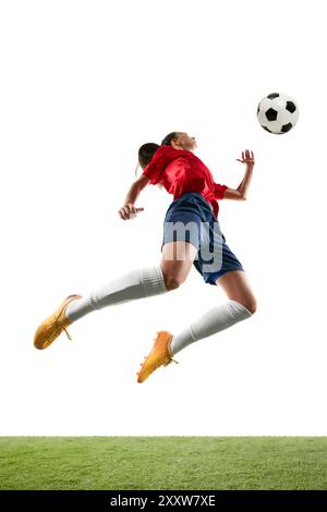 Grand joueur de football féminin sautant dans les airs pour frapper la balle avec la poitrine ou la tête sur le fond blanc isolé du stade. Banque D'Images