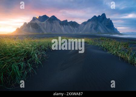 La majestueuse montagne Vestrahorn Stokksnes près de Hofn au coucher du soleil, plage de sable noir et herbe dans les dunes, ciel coloré, paysage islandais Banque D'Images