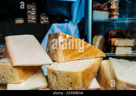 Pile de blocs de fromage enveloppés de plastique exposés dans une épicerie Banque D'Images