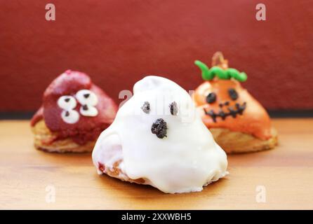 Trois des croissants glacés de sucre en forme de Ghosts d'Halloween sur fond en bois Banque D'Images