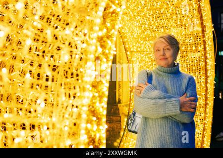 Portrait en gros plan extérieur de belle et heureuse femme de 55 à 60 ans visitant le marché de Noël Banque D'Images