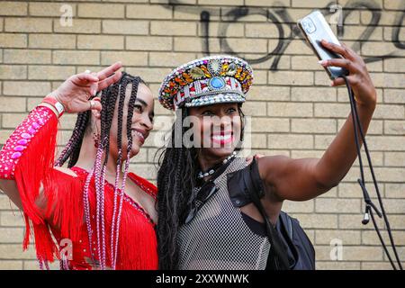 Londres, Royaume-Uni. 26 août 2024. Les selfies sont un must le long de la route. Notting Hill Carnival lundi voit la procession principale du carnaval des mas bands, des batteurs et des groupes de Salsa, Samba et Soca des Caraïbes et d'Amérique du Sud. Les fêtards célèbrent le week-end des fêtes de fin de semaine en participant ou en regardant le long de la route du carnaval, dans les systèmes de sonorisation, les stands et les lieux le deuxième des deux jours des festivités du carnaval de Notting Hill. Crédit : Imageplotter/Alamy Live News Banque D'Images