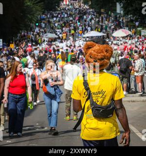 Londres, Royaume-Uni. 26 août 2024. Un fêtard avec un masque d'ours sur l'arrière de sa tête. Notting Hill Carnival lundi voit la procession principale du carnaval des mas bands, des batteurs et des groupes de Salsa, Samba et Soca des Caraïbes et d'Amérique du Sud. Les fêtards célèbrent le week-end des fêtes de fin de semaine en participant ou en regardant le long de la route du carnaval, dans les systèmes de sonorisation, les stands et les lieux le deuxième des deux jours des festivités du carnaval de Notting Hill. Crédit : Imageplotter/Alamy Live News Banque D'Images