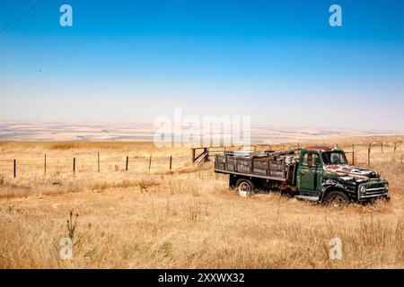 Un camion emblématique se trouve abandonné dans le cadre pittoresque de Pendleton, Oregon, avec ses collines vallonnées créant un contraste saisissant et pittoresque Banque D'Images