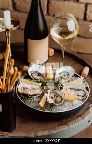 Huîtres élégantes sur glace avec citron et vin blanc, parfaites pour les repas gastronomiques et les occasions spéciales Banque D'Images