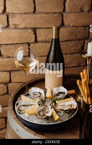 Huîtres élégantes sur glace avec citron et vin blanc, parfaites pour les repas gastronomiques et les occasions spéciales Banque D'Images