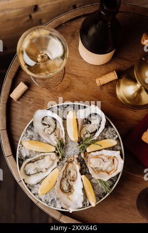 Huîtres élégantes sur glace avec citron et vin blanc, parfaites pour les repas gastronomiques et les occasions spéciales Banque D'Images