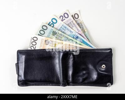 Portefeuille en cuir noir avec billets de banque polonais de 200, 100, 50, 20 et 10 zloty polonais. Il y a de l'argent qui sort du portefeuille. Banque D'Images