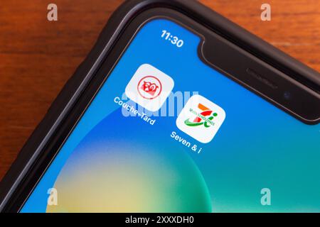 Couche-tard et Seven et I Holdings co icônes vus dans un iPhone. Couche-tard a proposé d'acquérir Seven & i Holdings pour se développer en Asie-Pacifique Banque D'Images