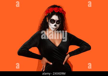 Jeune femme afro-américaine habillée pour Halloween sur fond orange Banque D'Images