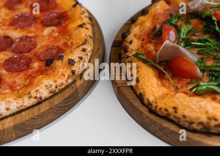 Set à pizza avec viande et fromage. Pizza pepperoni avec roquette et prosciutto. Pizza à la viande avec fromage, tomates cerises et poivre jalapeno chaud sur un blanc Banque D'Images