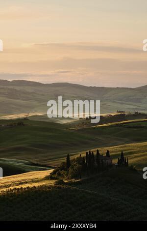 Une ferme dans les collines de la Val d'Orcia au lever du soleil Banque D'Images