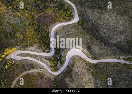 Belle vue aérienne de dessus de drone de route avec des courbes dans le paysage de montagne avec un van social distance près de Piodao, Serra da Estrela au Portugal Banque D'Images