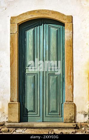 Ancienne porte de l'église historique d'âge et en bleu-vert bois dans la ville d'Ouro Preto, Minas Gerais avec un châssis de pierre Banque D'Images