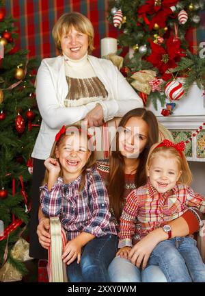 Portrait d'une grand-mère et petites-filles de l'adolescence près de l'arbre de Noël d'être heureux et joyeux Banque D'Images