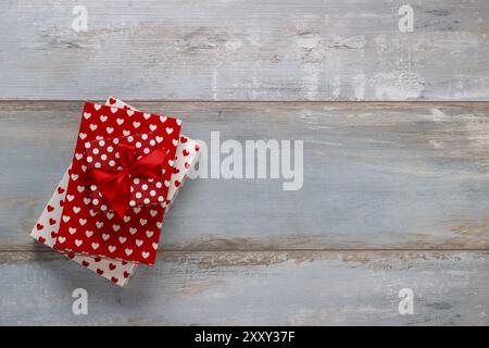 Coffrets cadeaux enveloppés dans du papier polkadots avec des rubans sur fond de bois, style rétro vintage Banque D'Images