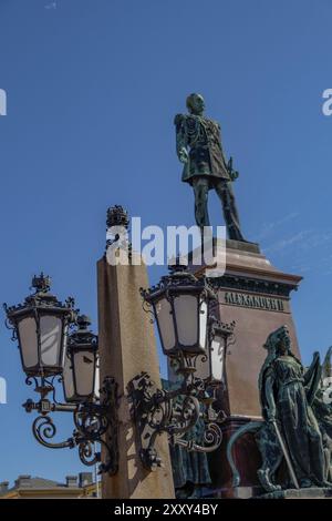 Grande statue en bronze sur un piédestal avec des lampadaires ornés sous un ciel bleu clair, Helsinki, Finlande, Europe Banque D'Images