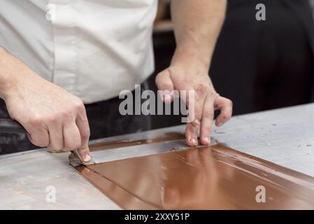 Confiseur professionnel fabriquant des bonbons au chocolat à la confiserie Banque D'Images