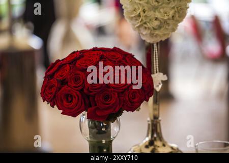 Bouquet de mariage rouge vif de roses debout dans un vase Banque D'Images