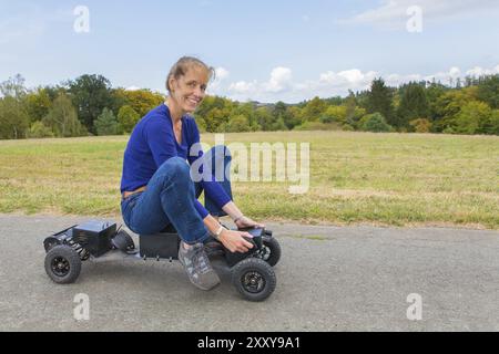 Dutch woman rides mountainboard électrique sur la nature en allemand Banque D'Images