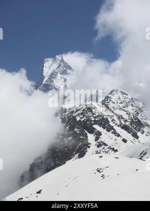 Pic du célèbre Machapuchare, montagne Fish Tail, entouré de nuages Banque D'Images