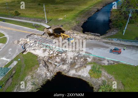 Construction de routes. Excavatrice réparant le pont détruit après que l'ouragan a inondé l'asphalte en Floride. Matériel de construction sur la route Banque D'Images