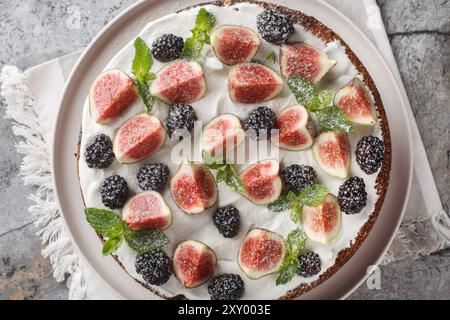 Gâteau d'automne avec figues, mûres et fromage ricotta gros plan dans une assiette sur la table. Vue horizontale de dessus Banque D'Images