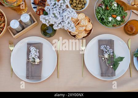 Élégante table pour dîner avec des arrangements floraux, des plats gastronomiques et de la vaisselle élégante créant une atmosphère sophistiquée pour les clients de profiter de leur repas à une table magnifiquement décorée Banque D'Images