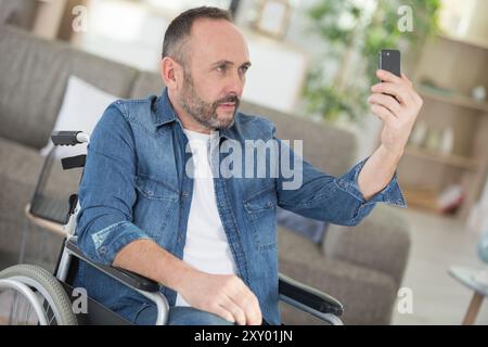 bel homme handicapé paraplégique faisant un selfie Banque D'Images