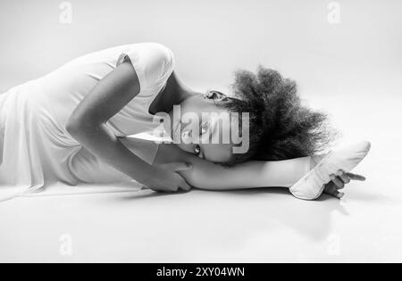 Ballerine en cours de danse. Flexible petite ballerine afro-américaine fille. Studio de ballet de fille africaine. Fille tutu blanc, léotard apprenant à danser Banque D'Images