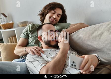 Quelques câlins sur un canapé, un homme regardant avec amour son partenaire. Banque D'Images