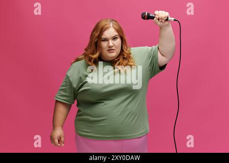 Une femme aux cheveux roux tient un micro et chante avec une expression confiante. Banque D'Images