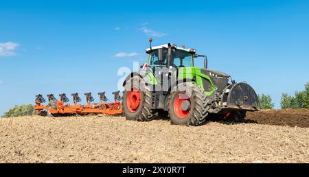 Tracteur avec charrue réversible à 7 lames et packer dans le champ, après la récolte des céréales - 2207 Banque D'Images