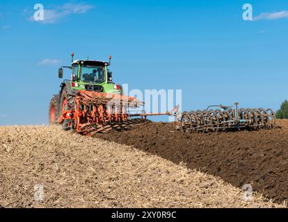 Tracteur avec charrue réversible à 7 lames et packer dans le champ, après la récolte des céréales - 2248 Banque D'Images