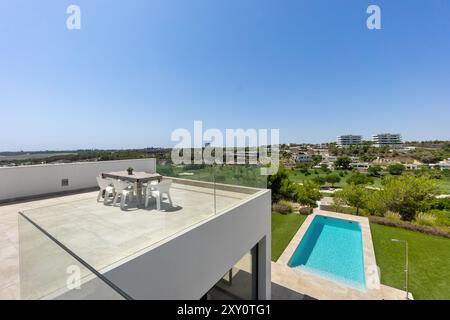 Cette superbe image met en valeur un toit-terrasse au design moderne, avec une piscine immaculée et un service à manger, avec une vue panoramique sur lu Banque D'Images
