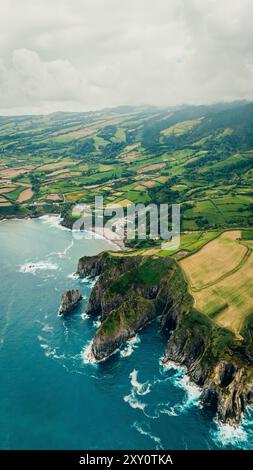 Cette photo aérienne capture la beauté étonnante des Açores avec ses champs verdoyants, ses falaises accidentées et la côte atlantique sauvage idéale pour les showcasi Banque D'Images