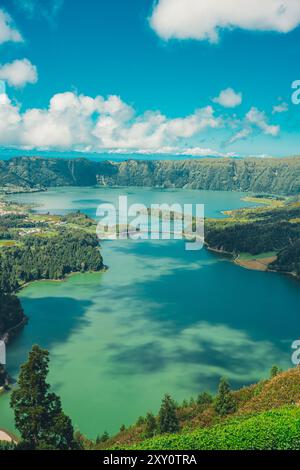 Superbe vue aérienne sur les eaux bleues et vertes vives de Lagoa das Sete Cidades, entouré de collines verdoyantes et luxuriantes sous un ciel moucheté de nuages dans le Banque D'Images