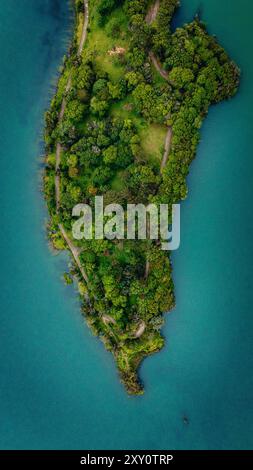 Superbe photo prise par drone capturant le paysage verdoyant et luxuriant d'une île des Açores, face aux eaux turquoise vibrantes de l'île environnante Banque D'Images