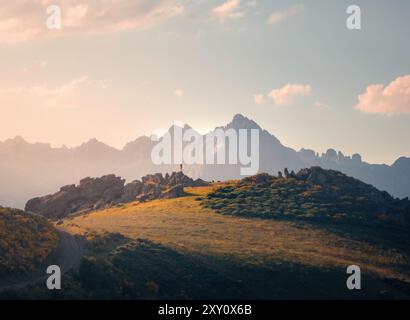 Vue arrière d'une personne méconnaissable debout sur une colline rocheuse dans les Picos de Europa, Cantabrie. L'image capture la beauté sereine du lever du soleil avec mi Banque D'Images