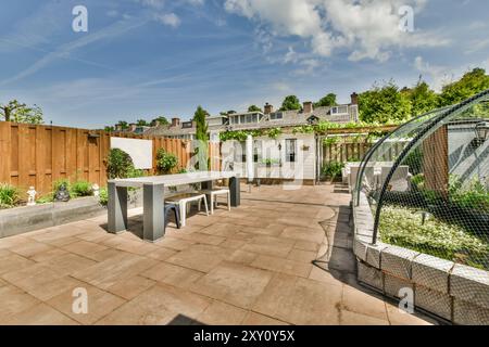 Arrière-cour de banlieue tranquille avec mobilier de patio moderne et un étang décoratif entouré d'une végétation luxuriante. Banque D'Images