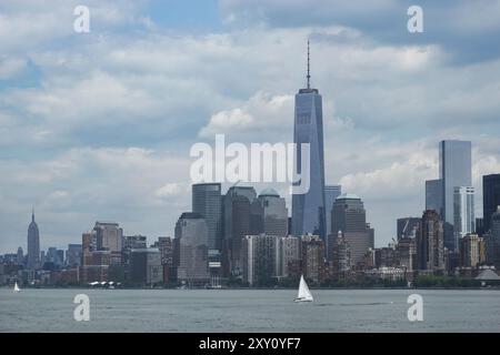 Une vue imprenable sur Manhattan, New York, avec l'éminent One World Trade Center et d'autres gratte-ciel sur fond de nuages épars A. Banque D'Images