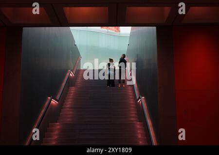 Milan, Italie- 22 juin 2024 : couple montant les escaliers à l'entrée du Musée des cultures Mudec dans le vieux quartier d'Ansaldo Banque D'Images