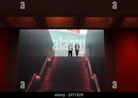 Milan, Italie- 22 juin 2024 : couple montant les escaliers à l'entrée du Musée des cultures Mudec dans le vieux quartier d'Ansaldo Banque D'Images