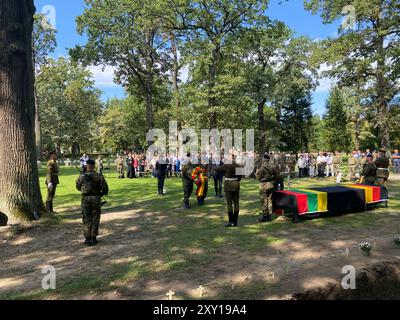 Kaunas, Lituanie. 27 août 2024. Les soldats de la Bundeswehr portent une couronne qui est déposée au nom de l'Allemagne en mémoire des morts de guerre. Avec une cérémonie commémorative au cimetière de guerre allemand, le Volksbund Deutsche Kriegsgräberfürsorge enterrera symboliquement le millionième mort allemand depuis la chute du rideau de fer. Crédit : Alexander Welscher/dpa/Alamy Live News Banque D'Images