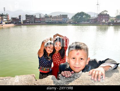 Bhaktapur, Népal - 15 novembre 2023 : les enfants népalais posent à l'extérieur regarder la caméra sur les célébrations du festival porter des vêtements traditionnels, ayant un bindi rouge Banque D'Images