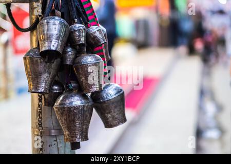 Beaucoup de vieilles cloches en métal accrochées sur le pilier dans le temple bouddhiste Banque D'Images