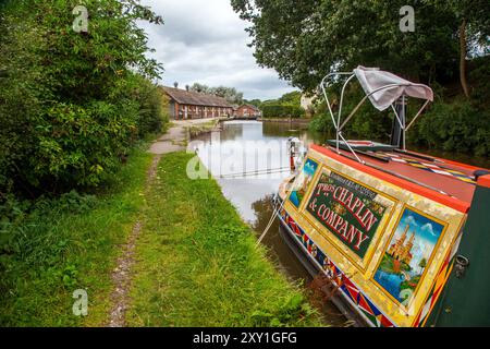 Canal étroit amarré sur le Shropshire Union canal approchant les écluses de Bunbury et les anciennes écuries dans la campagne du Cheshire Banque D'Images