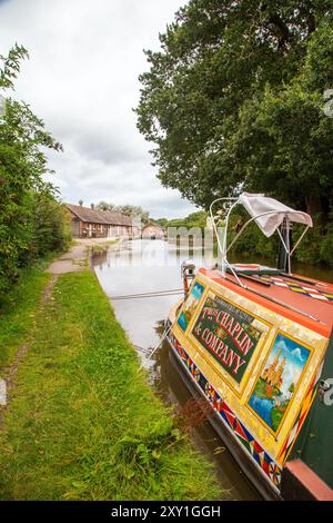 Canal étroit amarré sur le Shropshire Union canal approchant les écluses de Bunbury et les anciennes écuries dans la campagne du Cheshire Banque D'Images