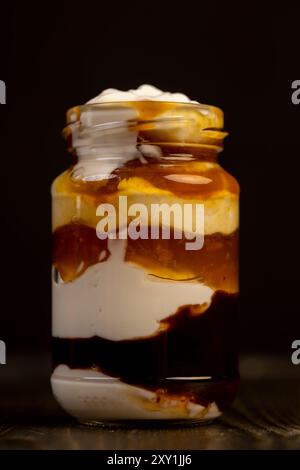 yaourt en couches avec confiture et morceaux de nectarine, yaourt naturel dans un pot en verre avec des fruits Banque D'Images
