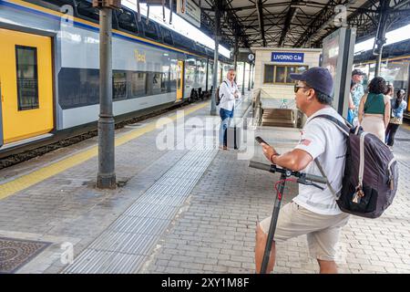 Livourne Italie, Piazza Dante, gare centrale de Livourne, attente passager de plate-forme, sac à dos scooter électrique homme asiatique, Europ italien Banque D'Images